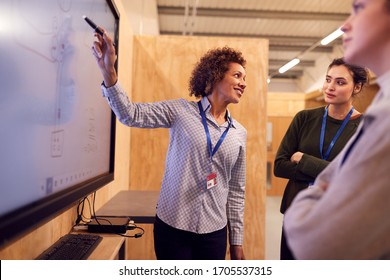 Tutor With Trainee Electricians Studying For Apprenticeship  Looking At Wiring Diagram On Screen - Shutterstock ID 1705537315