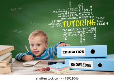TUTORING, education concept. Young boy sitting at the office desk and two binders