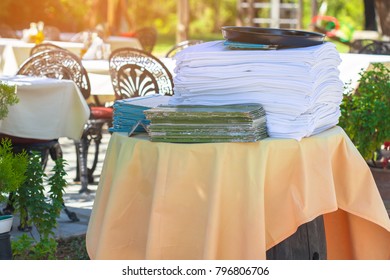 Tutu white tablecloth is on the table. A stack of menus in the area, staff café. The interior of the restaurant is outdoors - Powered by Shutterstock