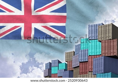 Tuvalu flag and big stack of shipping cargo containers in docks with sky background close up