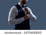 Tux suit, cropped view. Man with bow tie isolated on grey. Stylish man in elegant black suit. Gentleman in tuxedo vest. Businessman at formal event. Groom has tuxedo style. Tux of gentleman. Elegance