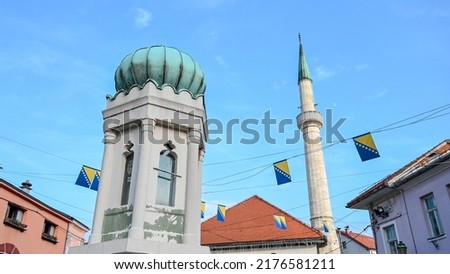 Tuzla, Bosnia and Herzegovina. Main square in city centre. Minaret and mosque. Flag of Bosnia and Herzegovina. 