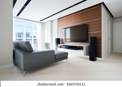 TV Area In The Modern Hi Tech Living Room: French Window, Grey Corner Sofa, Acoustic System And Solid Walnut Wall Panels