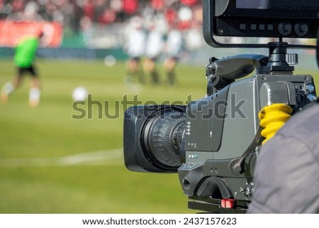 TV camera at the stadium, broadcasting during a football, soccer match