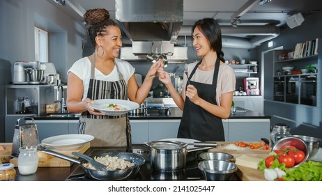 TV Cooking Show Kitchen with Two Master Chefs. Asian and Black Female Presenters Talk on Camera, Teach How to Cook Food, Taste Delicious Dish and Celebrate with High-Five. Online Video Class - Powered by Shutterstock