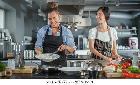 TV Cooking Show Kitchen With Two Master Chefs. Asian And Black Female Hosts Talk. Professionals Teach How To Cook Food, Taste Delicious Dish. Online Video Class Courses. Healthy Dish Recipe Prepare