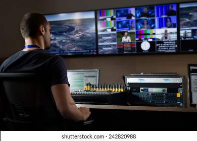 TV engineer at editor in studio. TV editor working with vision mixer in a television broadcast gallery.Man sat at a vision mixing panel in a television studio gallery - Shutterstock ID 242820988