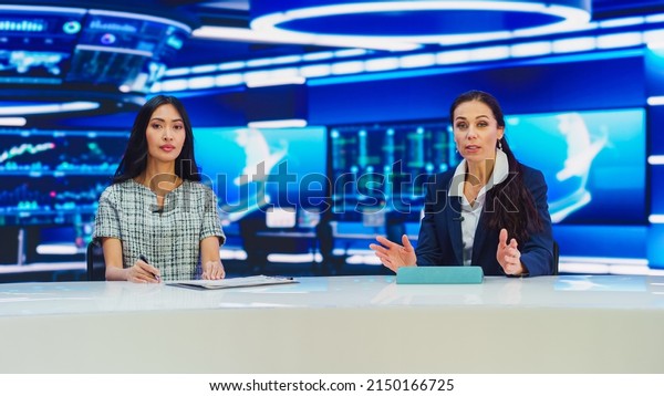 TV\
Live News Program: Two Presenters Reporting, Discuss Daily Events,\
Discuss Business, Economy, Science, Entertainment. Television Cable\
Channel Diverse Anchors Talk. Playback Newsroom\
Studio