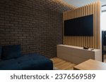 Tv on vertical wooden slats wall, living room of small urban apartment