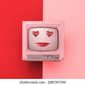 A TV with painted lips and heart-shaped eyes on a red and pink background. The concept of Valentine's Day. - Shutterstock ID 2087357590