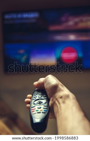 TV remote control in the hands of an elderly man