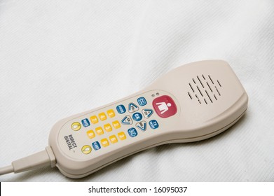 A TV remote control with a nurse call button.