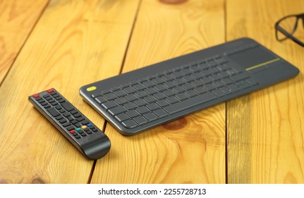 tv remote control with wireless keyboard on table next to each other - Powered by Shutterstock