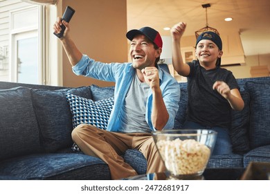 Tv remote, popcorn and dad with kid in celebration for television, network and bonding at home. Excited, son and man with fist in success for sports, winning and watching live broadcast together - Powered by Shutterstock