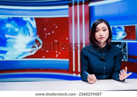 TV reporter covering latest topics live in newsroom, presenting daily events and incidents worldwide. Asian woman journalist hosting breaking news segment on international tv channel.