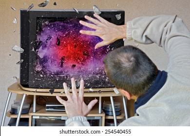 The TV Screen Explodes While Watching A TV Program. Shocked Man In Front Of A Television Display Exploding. Domestic Accident. Unhappiness In Home Entertainment.