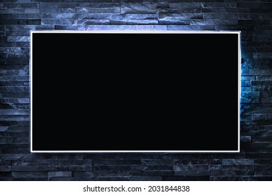 Tv Screen On Wall At Night In Dark With Led Light. Television And Flat Smart Monitor Display On Blue Brick Background. Modern Futuristic Loft Living Room Or Lounge. Empty Black Flatscreen.