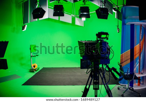 TV\
Studio recording show.Reportage shooting.TV NEWS program studio\
with video camera lens and lights.Positioned stage big professional\
broadcasting camera with headphones.Green key\
studio