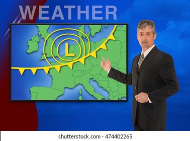 A Tv Television News Weather Meteorologist Anchorman Is Reporting With A Colorful European Map And Weather Graphics On The Monitor Screen.