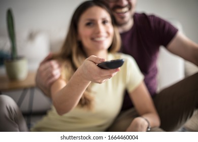 TV Time Can Be Quality Time Too. Happy Couple At Home Watching TV. Close Up. Focus On Hand.