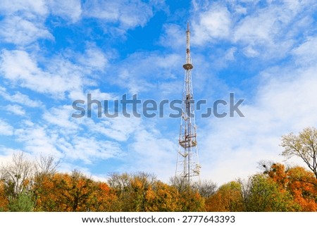 TV tower communication object above autumn top trees forest clear weather sky