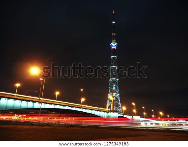 TV tower in Saint Petersburg at night\
on long exposure with blurred taillights of\
cars.