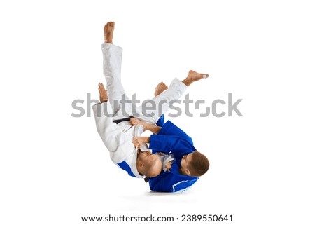 Tw fit man in uniform, professional sportsmen of martial arts, fighting, training before fight isolated white studio background. Concept of combat sport, health, strength, energy, fit. Copy space