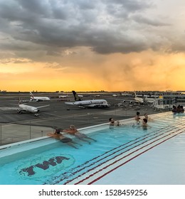 TWA Hotel airport rooftop pool bar at sunset at the John F. Kennedy Airport (JFK) with the view of airplanes at the John F. Kennedy Airport. Queens New York USA, October 2, 2019