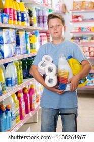 Tween Boy Standing Among Shelves In Supermarket, Holding Purchases 
