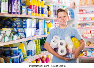 Tween Boy Standing Among Shelves In Supermarket, Satisfied With Household Chemicals