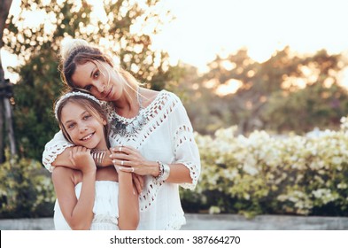 Tween Daughter Hugging With Her Mom In Summer Sunlight