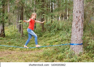 Tween girl balancing on slackline during summer holidays