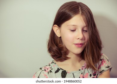 Tween Girl Looks Down With Mischevious Expression - With White Space