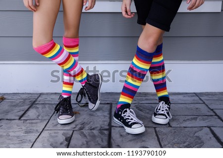 Tween Girls Legs with  Colorful Striped Socks and Tennis Shoes