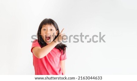 tween kid girl with pink shirt pointing finger with excited face looking camera.Advertising ad promotion.Asian student teen girl attention finger point.Education isolated background.portrait girl.