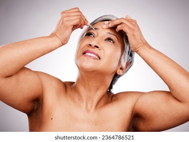 Tweezers, eyebrow and beauty of a mature woman in studio for skin care, cosmetics and makeup. Female person on a gray background for facial wellness, epilation and plucking hair with cleaning tools - Shutterstock ID 2364786521