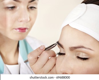 Tweezing Eyebrow By Beautician. Isolated.