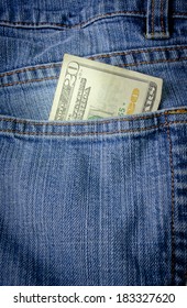 A Twenty Dollar Bill Sticking Out The Back Pocket Of Denim Blue Jeans