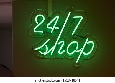 Twenty-four hours shop neon sign glowing on a wall