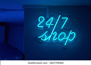 Twenty-four hours shop neon sign glowing on a wall