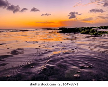 Twilight Coastal View: The photo showcases a serene coastal landscape at twilight with the sun setting in the background. The water is still, reflecting the soft colors of the sky - Powered by Shutterstock