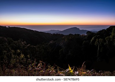 Twilight sky without cloud before sunrise over the dark mountains in the shadow.