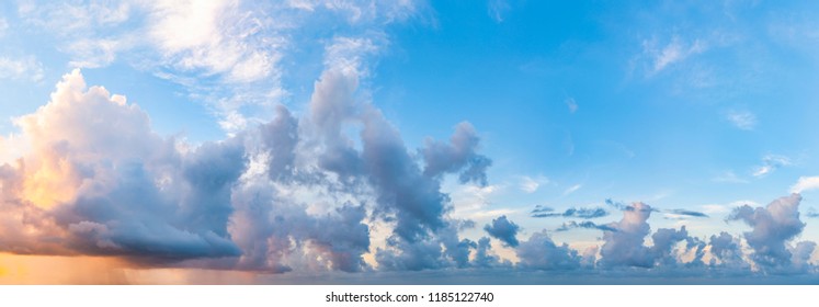 Twilight sunset with colorful clouds. Dramatic atmosphere created by the sunlight. Colorful gradient from blue to orange. Blue sky and clouds. High resolution panoramic sky.