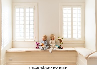 Twin Boys Playing With Stuffed Animals In Their Bedroom