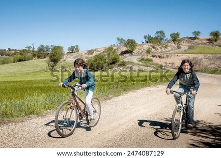 Similar – Image, Stock Photo Two teenagers race through the sunshine on a sled, dusted with snow