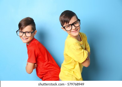 Twin brothers in glasses on blue background