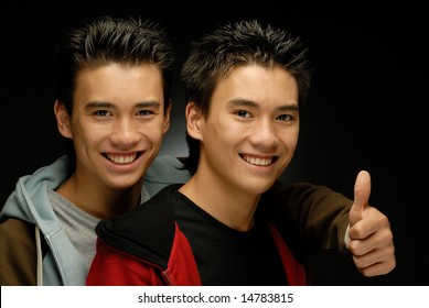 Twin brothers posing smiling gesturing OK