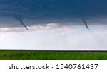 Twin funnel clouds from landspout tornadoes beneath a storm in Kansas