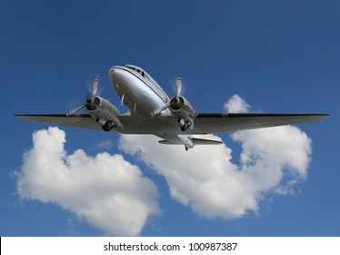  Twin Prop Cargo Plane Flying Through Blue Sky And Puffy Clouds In The Background. Front Left Side View With Spinning Propellers./ Vintage Airliner/Cargo Plane In Flight / Up In The Wild Blue Yonder.