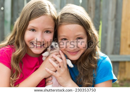 Twin sisters and puppy pet dog chihuahua playing together with doggy